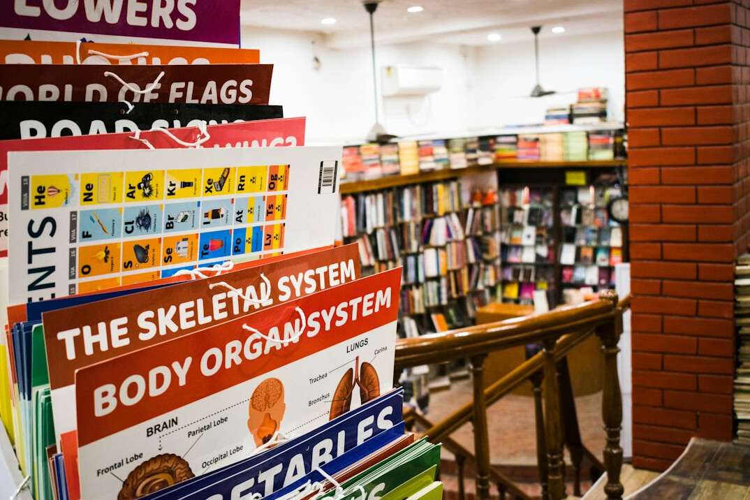 Stack of books and an open magazine on a table in a library